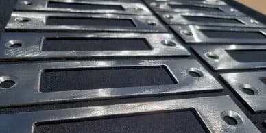Stack of identical CNC plasma cut steel parts from a production run